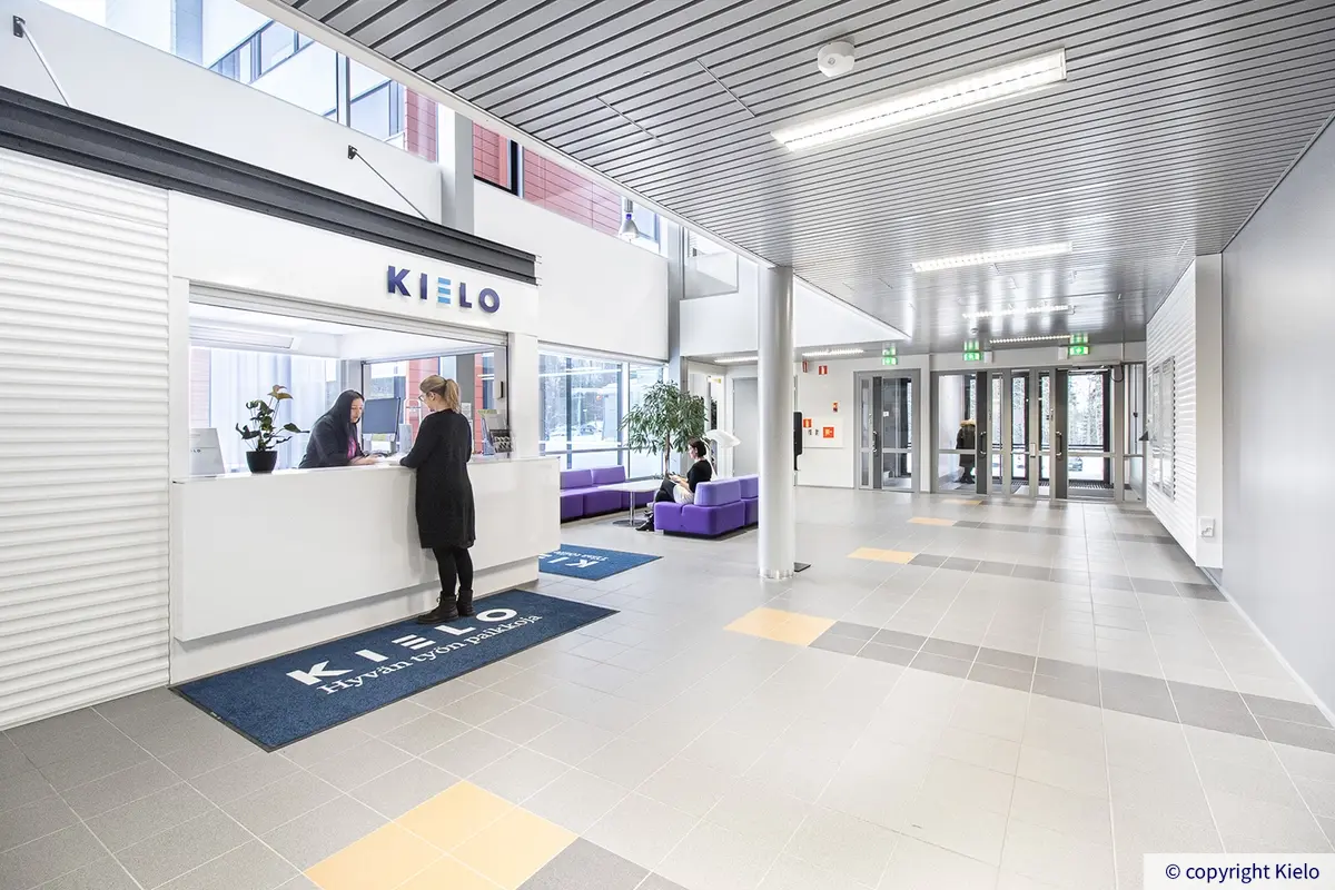 Jyväskylän Ohjelmakaari 2&10 valoisa aula, jossa vastaanottotiski ja sohvat odotustilassa.